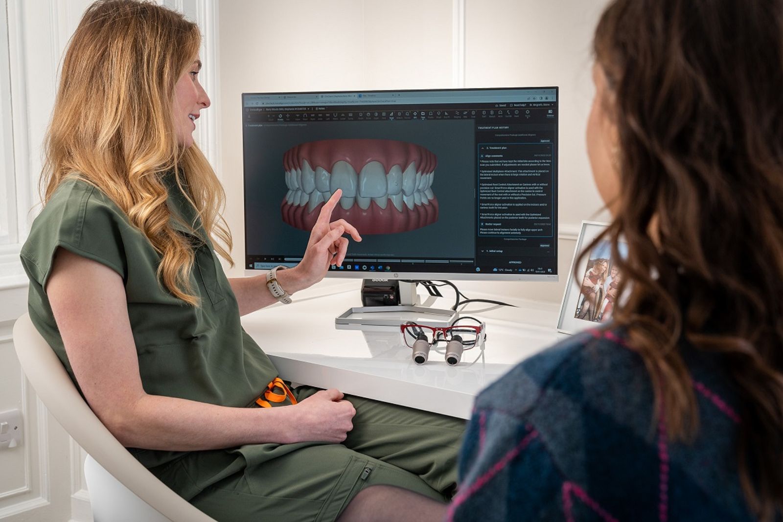 Dentista muestra a una paciente un modelo digital 3D de la dentadura para planificar la ortodoncia lingual